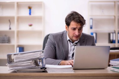 Ofisteki aşırı işten memnun olmayan genç bir çalışan.