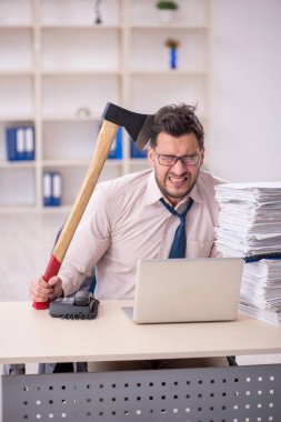 Young employee and too much work at workplace