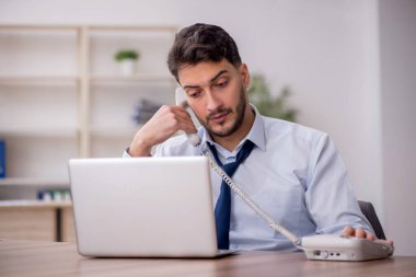 Young employee and too much work at workplace