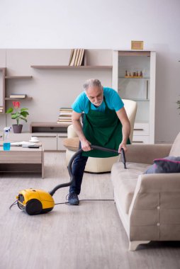 Yaşlı müteahhit evi temizliyor.