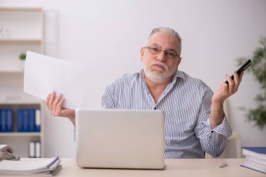 Old employee working at workplace