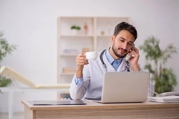 stock image Young doctor drinking coffee during break