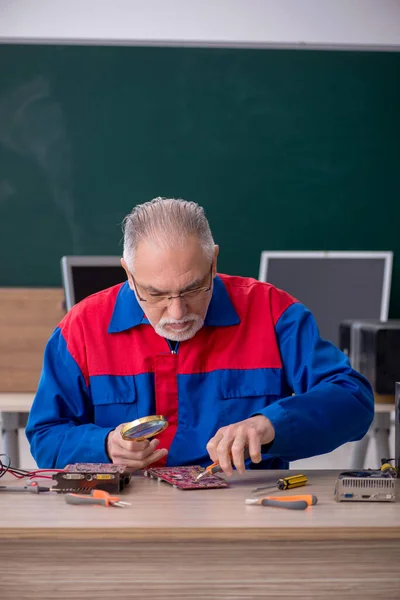 Öreg Férfi Szerelő Számítógépeket Javít Osztályteremben — Stock Fotó