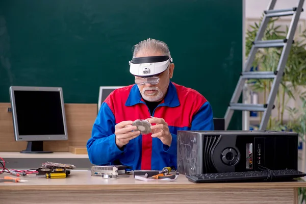교실에서 컴퓨터를 수리하고 나이든 수리공 — 스톡 사진