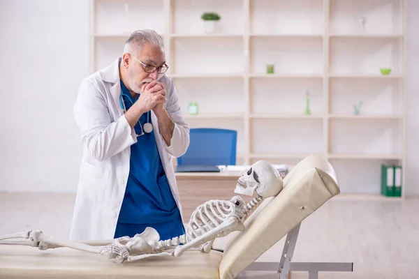Old male doctor and skeleton patient at the hospital