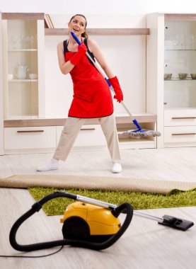 The young beautiful woman cleaning apartment