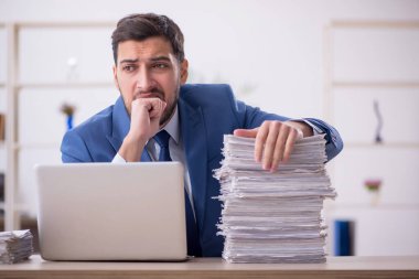 Genç bir çalışan ve ofiste çok fazla iş var.