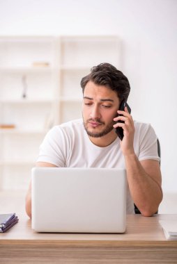 Genç çalışan işyerinde oturuyor.