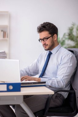 Young employee and too much work at workplace