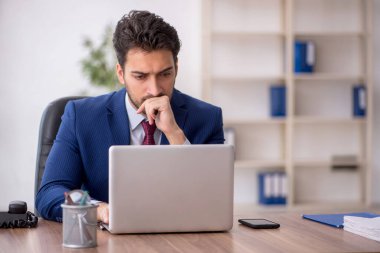 Genç çalışan işyerinde oturuyor.