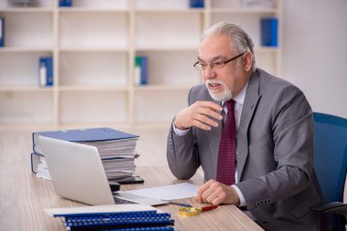 Eski patron işyerinde oturuyor.