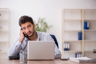 Genç çalışan işyerinde oturuyor.