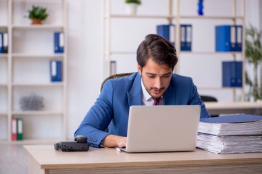 Genç işadamı ve ofiste çok fazla iş var.