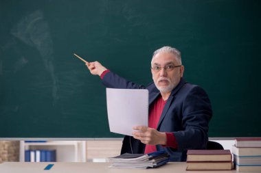 Old teacher sitting in the classroom