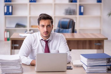 Genç işadamı işyerinde oturuyor.