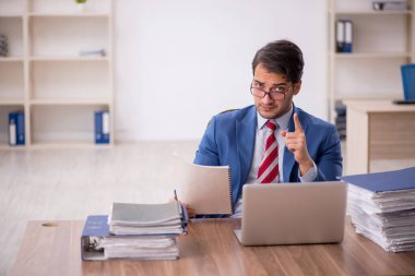 Genç işadamı işyerinde oturuyor.