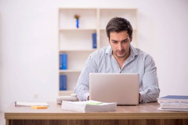 Genç işadamı işyerinde oturuyor.