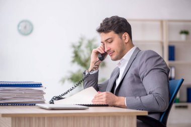 Young employee and too much work at workplace