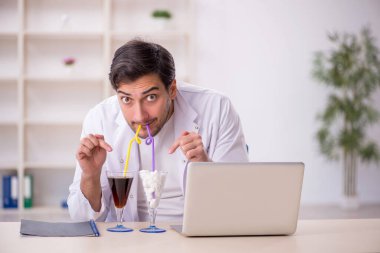 Laboratuvarda alkolsüz içeceği inceleyen genç bir kimyager.