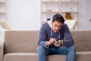 Evde televizyon izleyen genç bir erkek öğrenci.