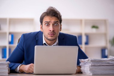 Genç işadamı ve ofiste çok fazla iş var.