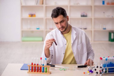 Young chemist sitting at the lab