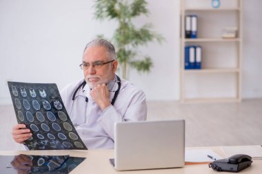 Klinikte çalışan yaşlı bir radyolog.