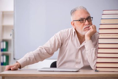 Old teacher sitting in the classroom