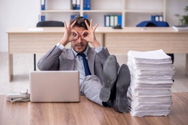 Young employee and too much work at workplace