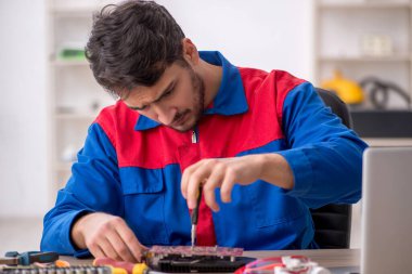 Laboratuvarda bilgisayar tamir eden genç bir tamirci.