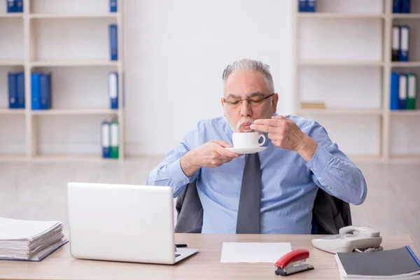 休憩中に古い従業員がコーヒーを飲む — ストック写真