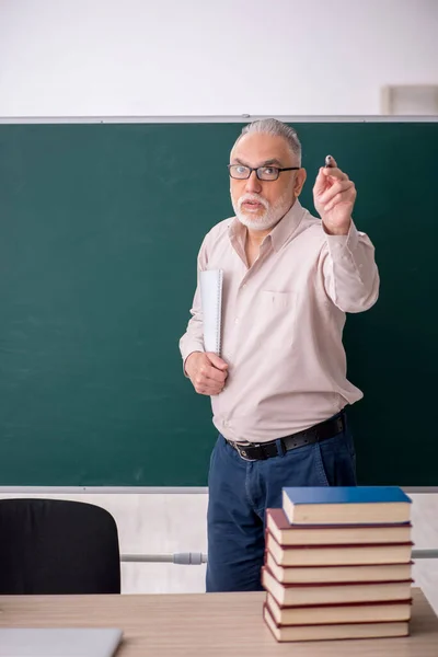 Old teacher sitting in the classroom