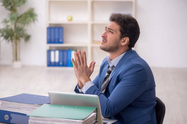 Genç işadamı ve işyerinde çok fazla iş var.