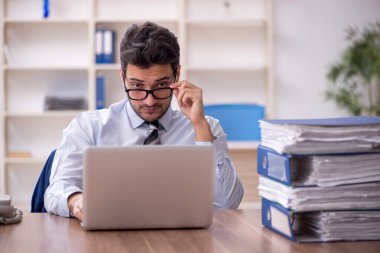 Genç işadamı ve işyerinde çok fazla iş var.