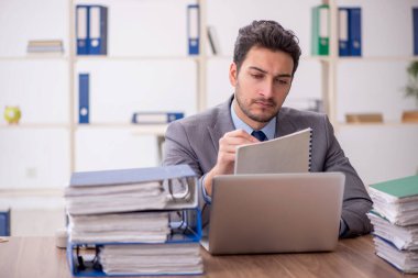Young employee and too much work at workplace