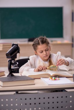 Little girl in drugs synthesis concept in the classroom