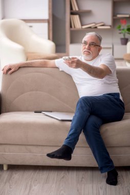 Old man sitting at home during pandemic