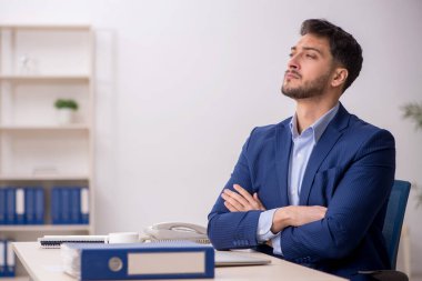 Genç çalışan işyerinde oturuyor.