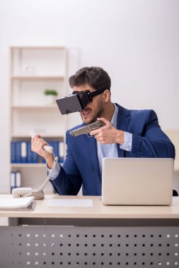 Genç çalışanın iş yerinde sanal gözlüklerle eğlenmesi