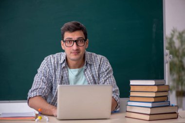 Sınıfta oturan genç öğrenci.