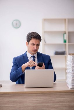 Young employee and too much work at workplace