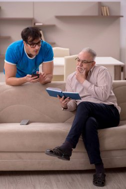 Young student and his grandfather at home
