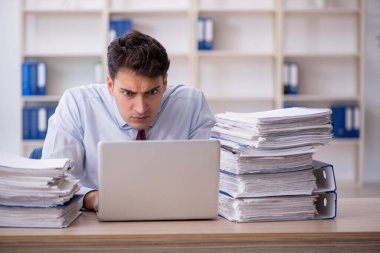 Young employee and too much work at workplace