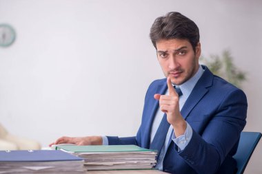 Genç işadamı işyerinde oturuyor.