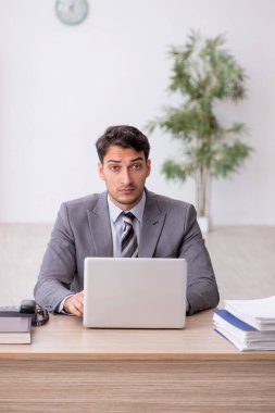 Genç çalışan işyerinde oturuyor.