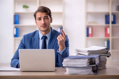 Genç işadamı ve ofiste çok fazla iş var.