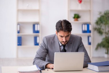 Genç işadamı işyerinde oturuyor.