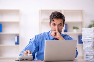 Genç işadamı ve ofiste çok fazla iş var.