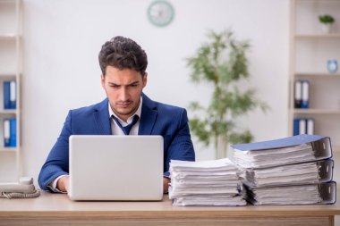 Ofisteki aşırı işten memnun olmayan genç bir çalışan.