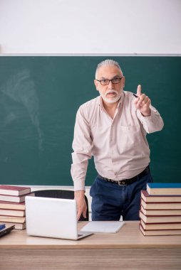 Old teacher sitting in the classroom